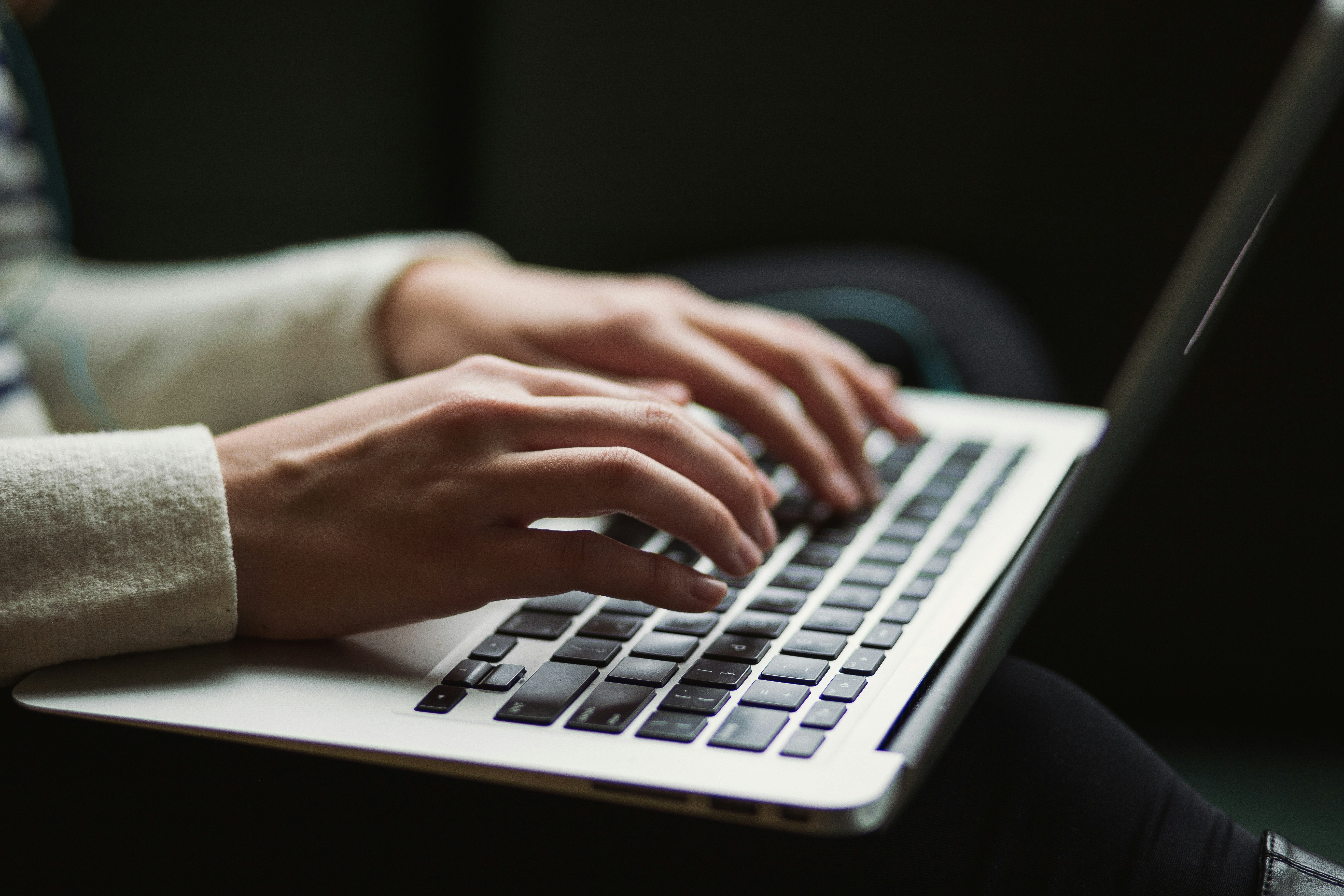 Person typing a blog on a laptop